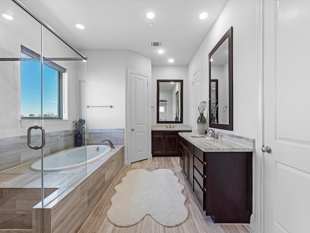 full bath with a stall shower, visible vents, vanity, a bath, and recessed lighting