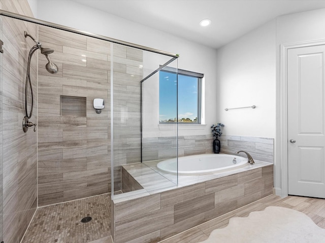 full bathroom featuring a garden tub and a shower stall