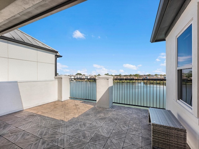 view of patio / terrace with a water view and a balcony