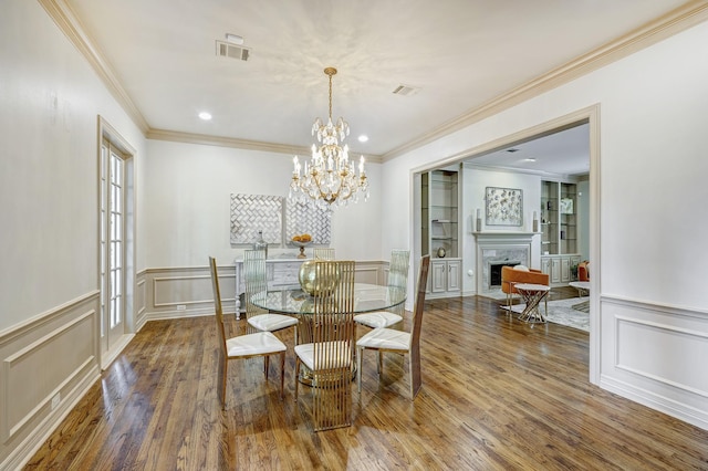 dining area featuring crown molding, dark hardwood / wood-style flooring, and a notable chandelier