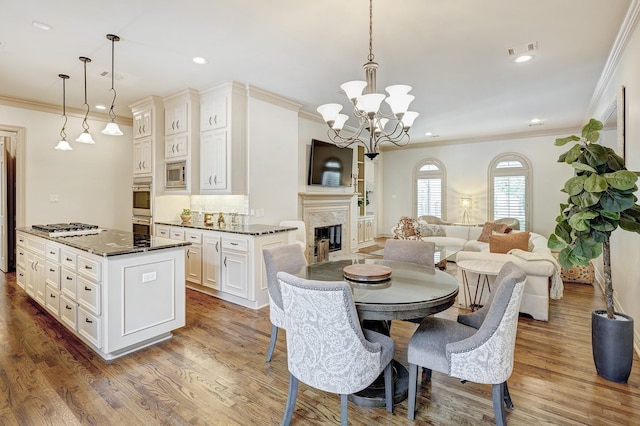 dining space featuring dark hardwood / wood-style flooring, an inviting chandelier, and crown molding