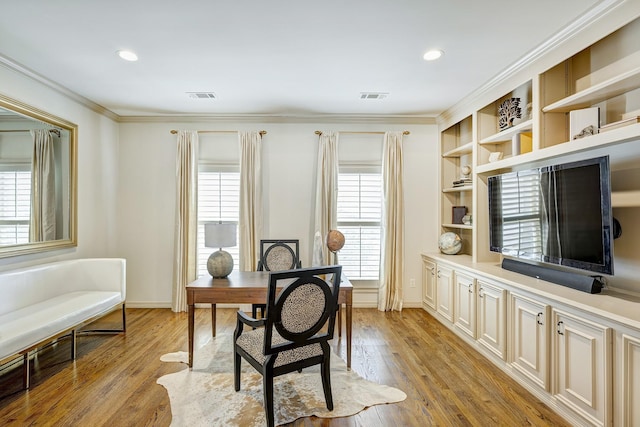 home office featuring light hardwood / wood-style flooring, built in features, and ornamental molding