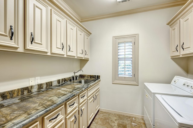 washroom featuring ornamental molding, sink, cabinets, and independent washer and dryer