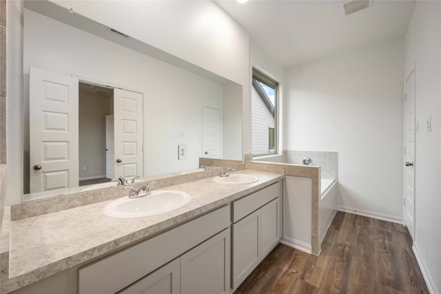 bathroom featuring vanity, a tub, and hardwood / wood-style flooring