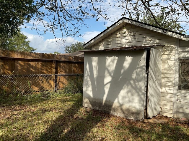 view of side of home featuring a storage shed and a lawn