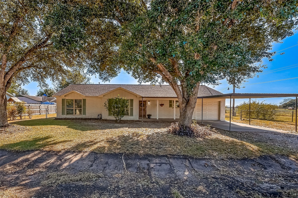 ranch-style home featuring a garage, a front lawn, and a carport