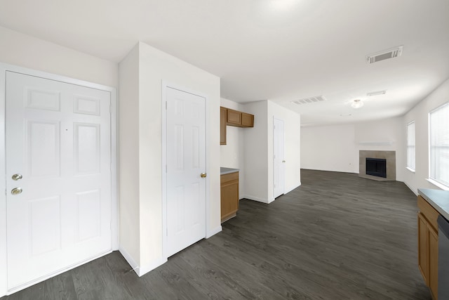 interior space featuring dishwasher, a fireplace, and dark hardwood / wood-style floors