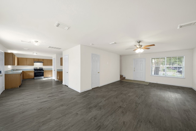 unfurnished living room with sink, ceiling fan, and dark hardwood / wood-style flooring