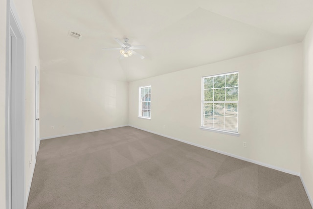 carpeted empty room featuring lofted ceiling, plenty of natural light, and ceiling fan