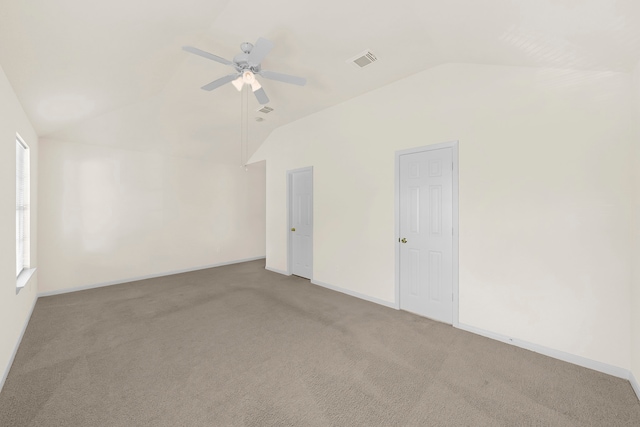 empty room with vaulted ceiling, carpet flooring, and ceiling fan