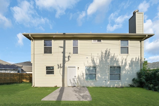 rear view of house featuring a lawn