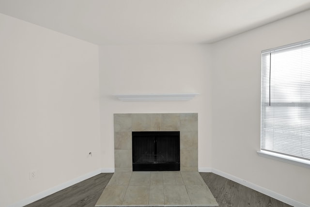 interior details featuring wood-type flooring and a tile fireplace