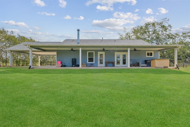 back of house featuring a lawn, a patio area, and french doors