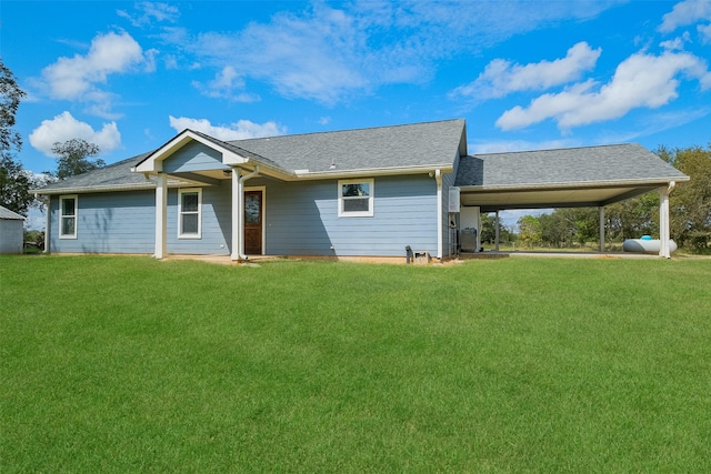 rear view of house with a carport and a lawn