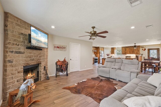10723 Fm 442nd Rd, Boling, TX 77420 - living area featuring ceiling fan, recessed lighting, baseboards, light wood-style floors, and a fireplace