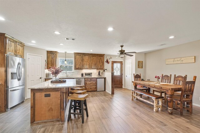 10723 Fm 442nd Rd, Boling, TX 77420 - kitchen featuring stainless steel appliances, brown cabinetry, a center island, a ceiling fan, and recessed lighting
