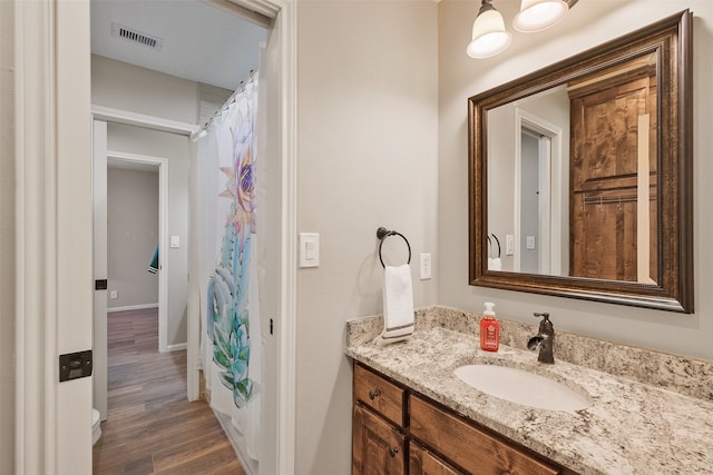 bathroom with curtained shower, hardwood / wood-style floors, and vanity