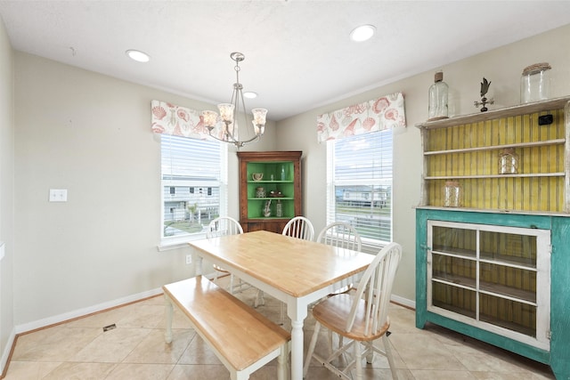 tiled dining room featuring a chandelier