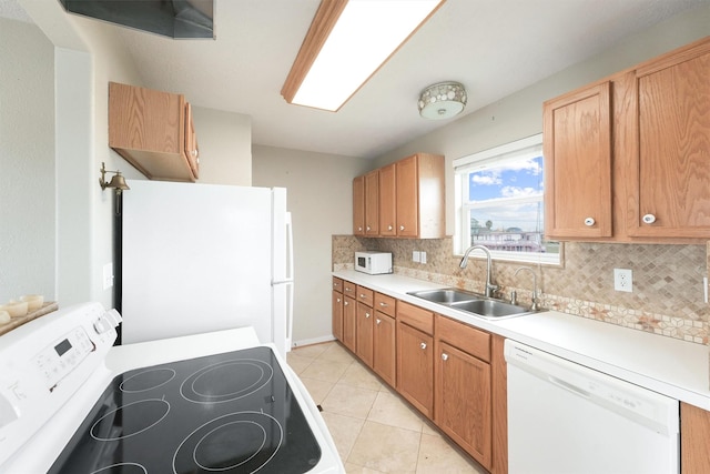 kitchen with tasteful backsplash, white appliances, light tile patterned floors, light countertops, and a sink