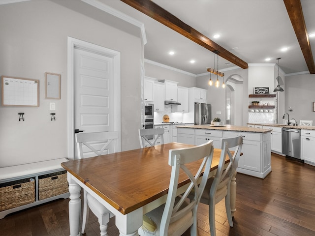 dining area with sink, beamed ceiling, ornamental molding, and dark hardwood / wood-style floors