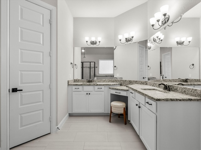 bathroom featuring vanity, a chandelier, and a shower with shower door