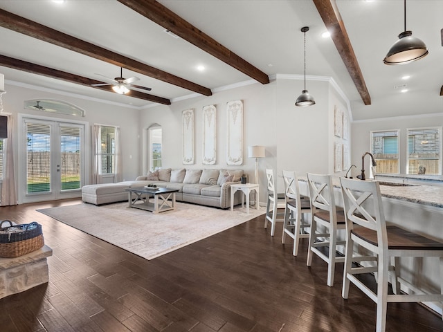 living room featuring ornamental molding, dark hardwood / wood-style floors, beamed ceiling, and ceiling fan