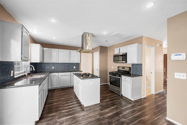 kitchen featuring island exhaust hood, appliances with stainless steel finishes, dark hardwood / wood-style flooring, and a kitchen island