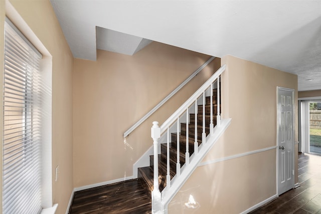 stairs with a textured ceiling and wood-type flooring