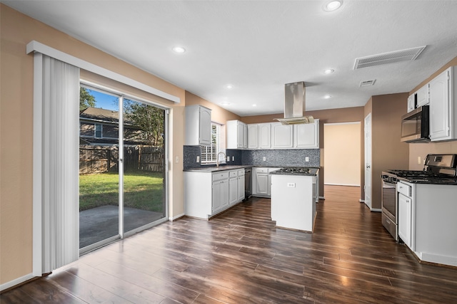 kitchen featuring dark wood-type flooring, appliances with stainless steel finishes, a center island, and white cabinetry