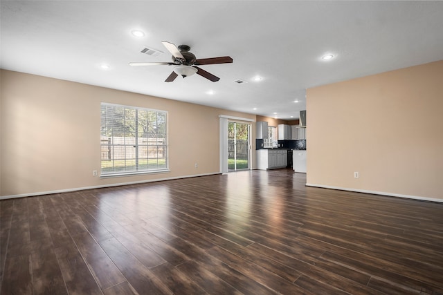 unfurnished living room with dark hardwood / wood-style floors and ceiling fan