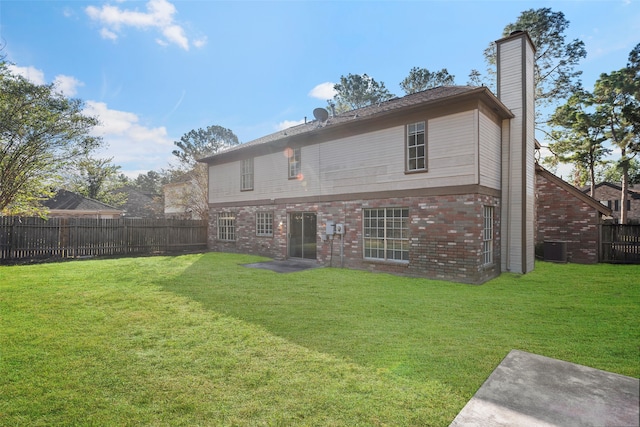 back of house featuring central air condition unit, a patio area, and a lawn