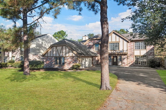 tudor house with a front yard and a garage