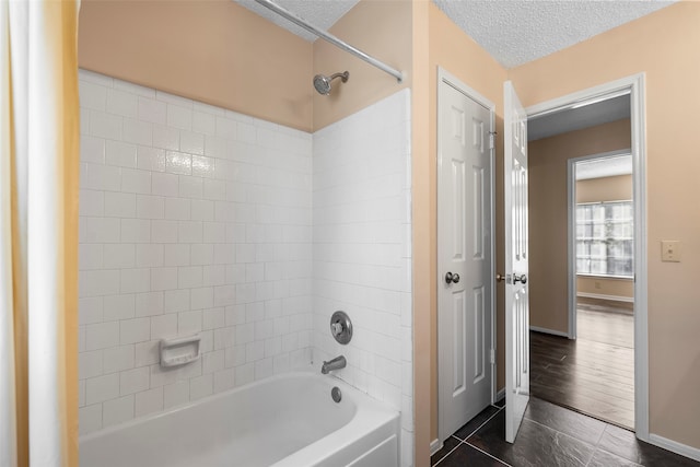 bathroom featuring wood-type flooring, a textured ceiling, and tiled shower / bath