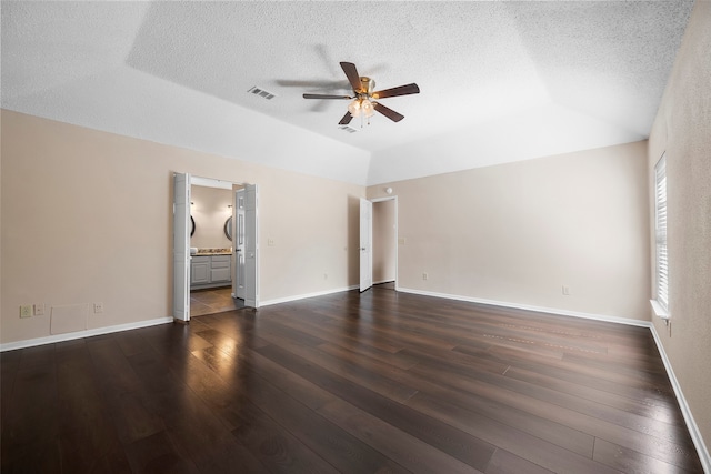 unfurnished living room featuring a textured ceiling, vaulted ceiling, dark hardwood / wood-style floors, and ceiling fan