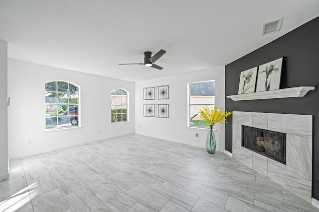 unfurnished living room featuring a fireplace and ceiling fan