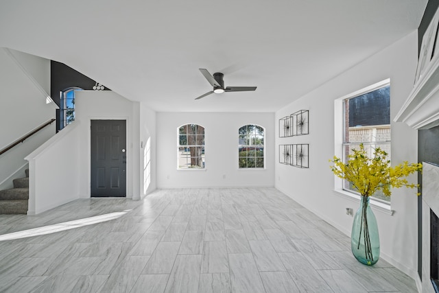 unfurnished living room featuring ceiling fan