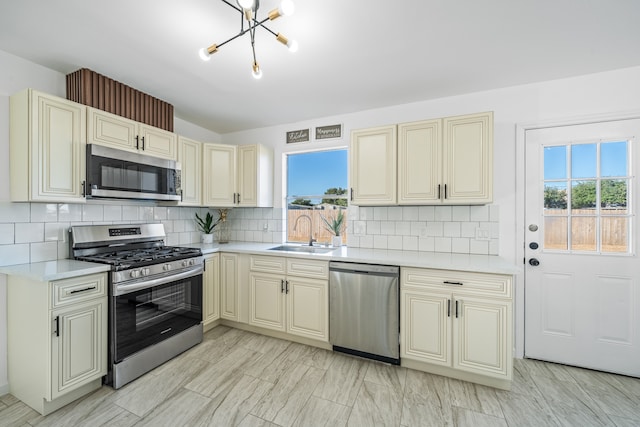 kitchen featuring a wealth of natural light, stainless steel appliances, and cream cabinets