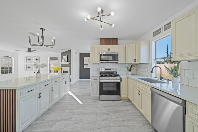 kitchen with stainless steel appliances, sink, and cream cabinetry