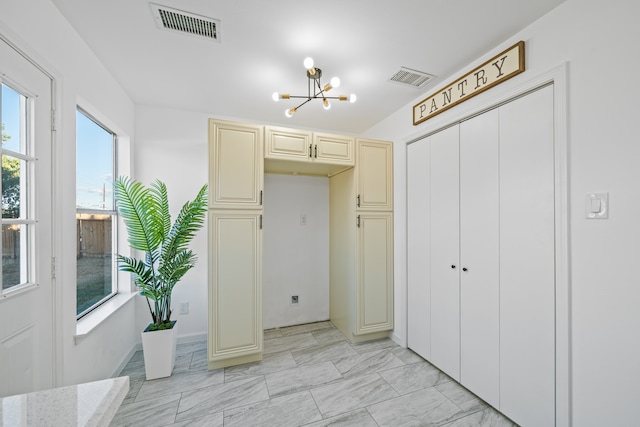 interior space featuring an inviting chandelier and a closet