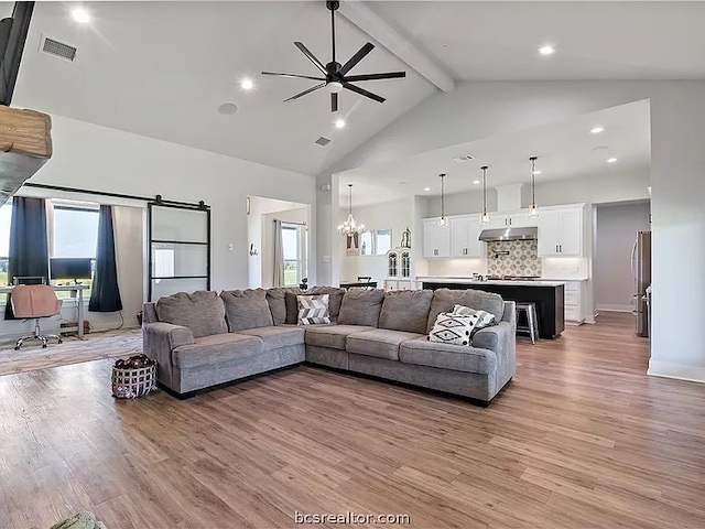 living room featuring light hardwood / wood-style floors, high vaulted ceiling, and plenty of natural light