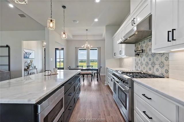 kitchen featuring white cabinets, hardwood / wood-style flooring, stainless steel appliances, range hood, and a center island