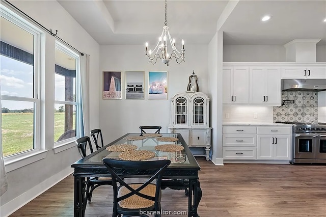 dining room with dark wood-type flooring and an inviting chandelier