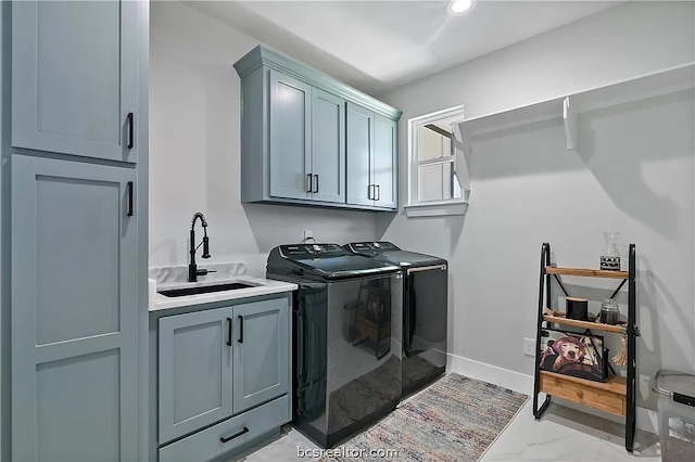 clothes washing area with cabinets, sink, and washing machine and clothes dryer