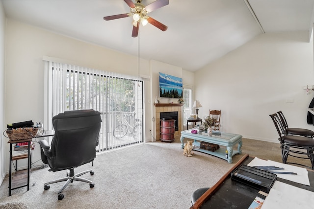 office space featuring ceiling fan, carpet flooring, a fireplace, and vaulted ceiling