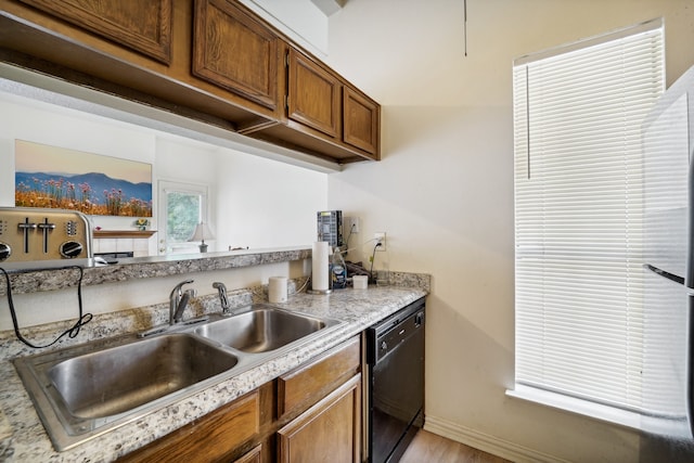 kitchen featuring sink, dishwasher, and light wood-type flooring