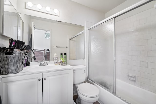 full bathroom with vanity, toilet, and combined bath / shower with glass door