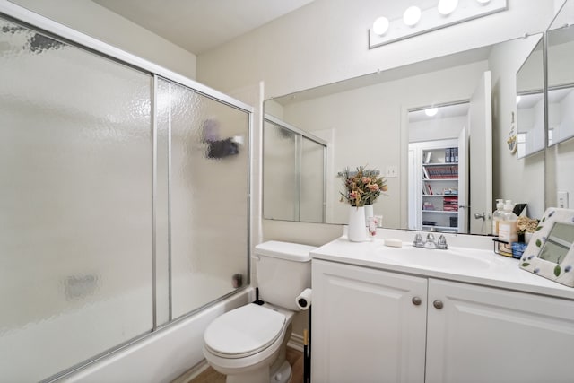 full bathroom featuring vanity, toilet, and bath / shower combo with glass door