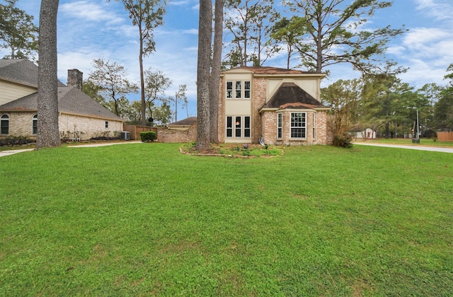 view of front of property with cooling unit and a front yard