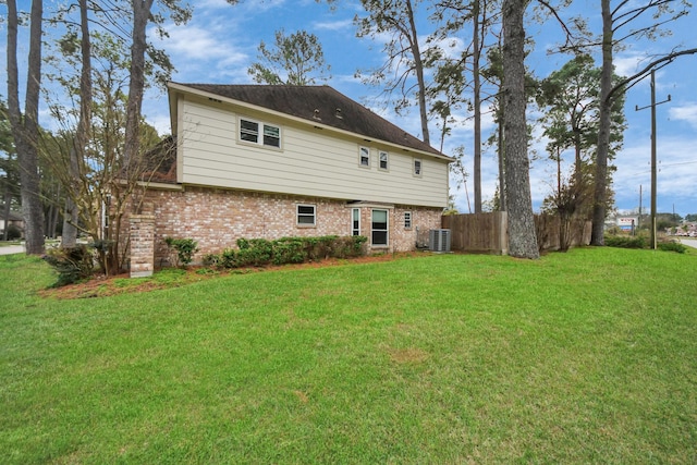 back of house featuring central AC unit and a lawn