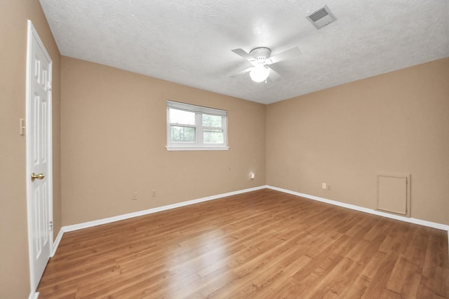 empty room featuring light hardwood / wood-style floors, ceiling fan, and a textured ceiling